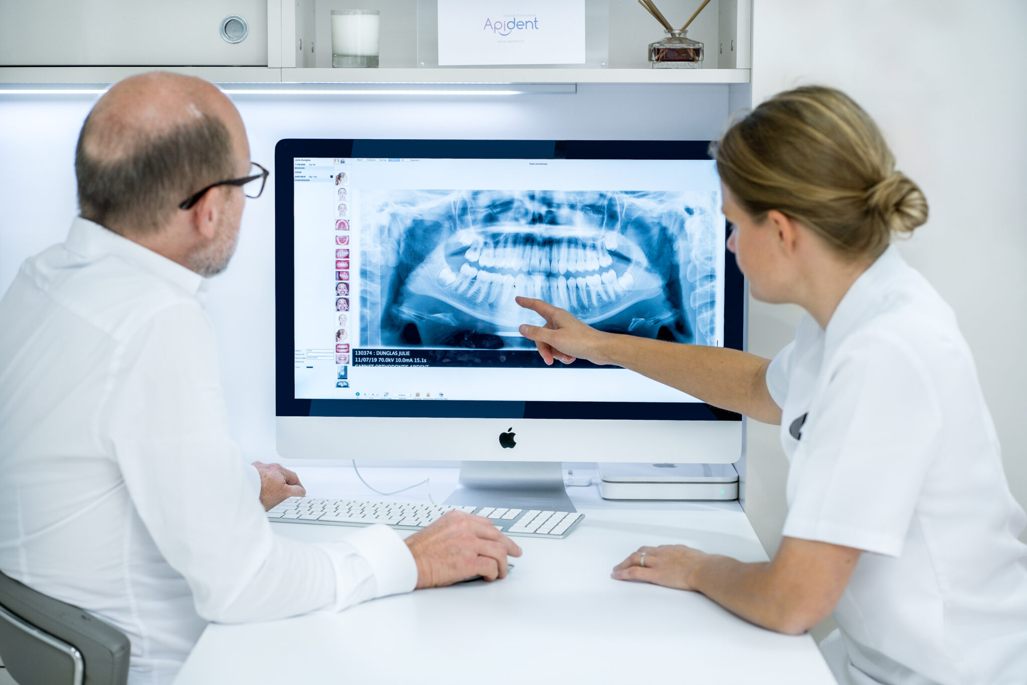 shooting Apident mise en scène 3 Deux orthodontistes examinent une radiographie dentaire sur un moniteur et discutent des options de traitement. Cette photo a été prise dans un studio professionnel.