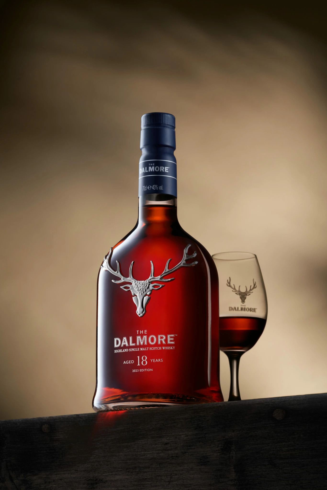 LMDW STILL LIFE DALMORE 02 La bouteille de scotch Dalmore 18 ans d'âge et le verre rempli de logos de cerfs argentés dans une composition de nature morte, fond brun flou.