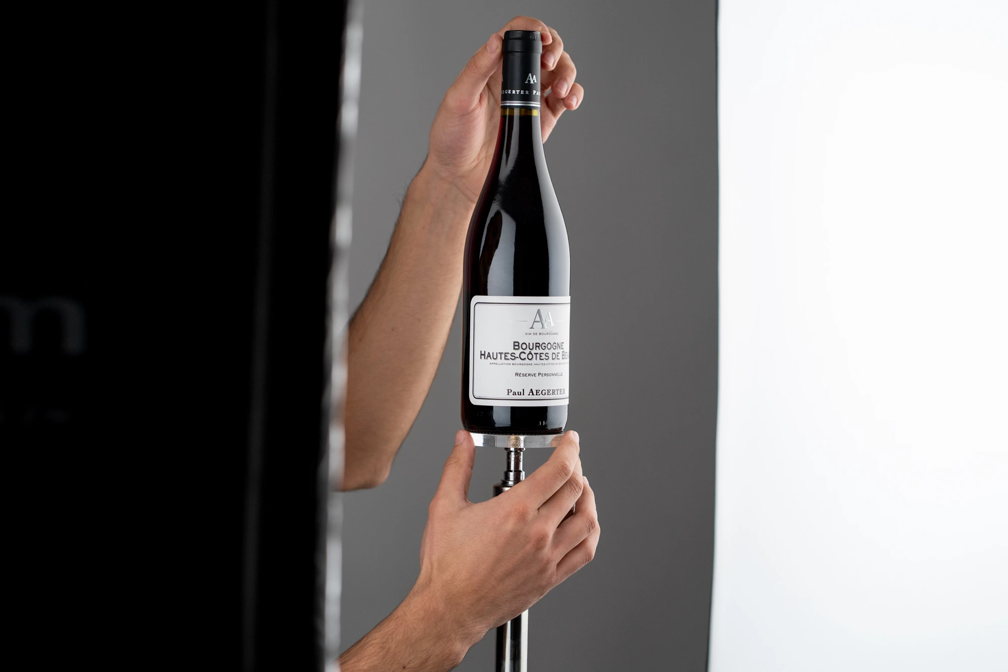 photographe de bouteille de vin en train de manipuler une bouteille de vin rouge