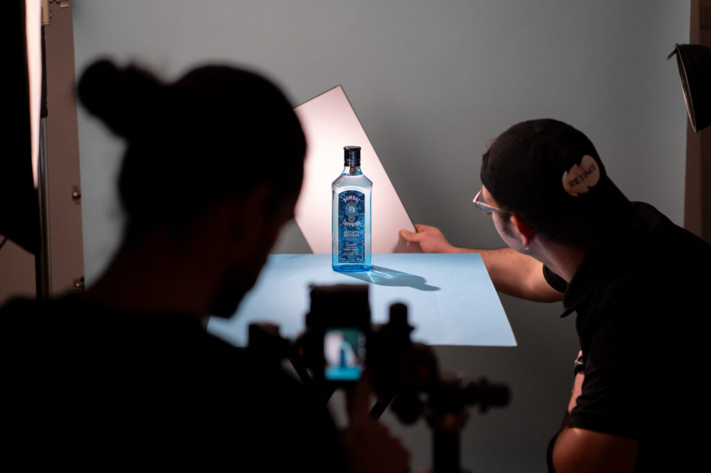 Photographie backstage d'un ajustement de la lumière sur une bouteille de gin