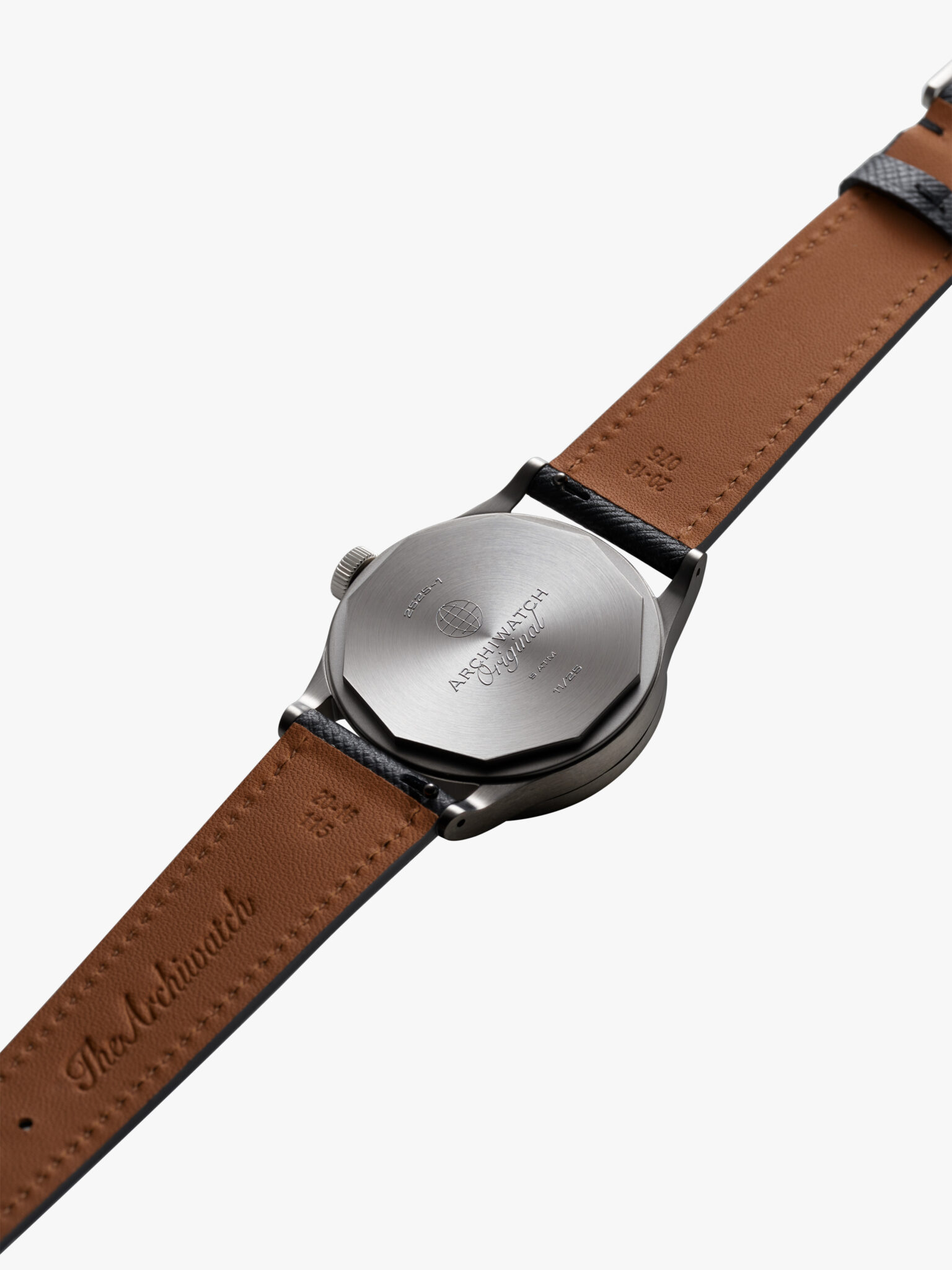 Photographie Archiwatch packshot photo montre horlergie 1 La photographie haute résolution du produit montre le dos de la montre-bracelet, avec un bracelet en cuir gaufré et un boîtier en métal gravé.