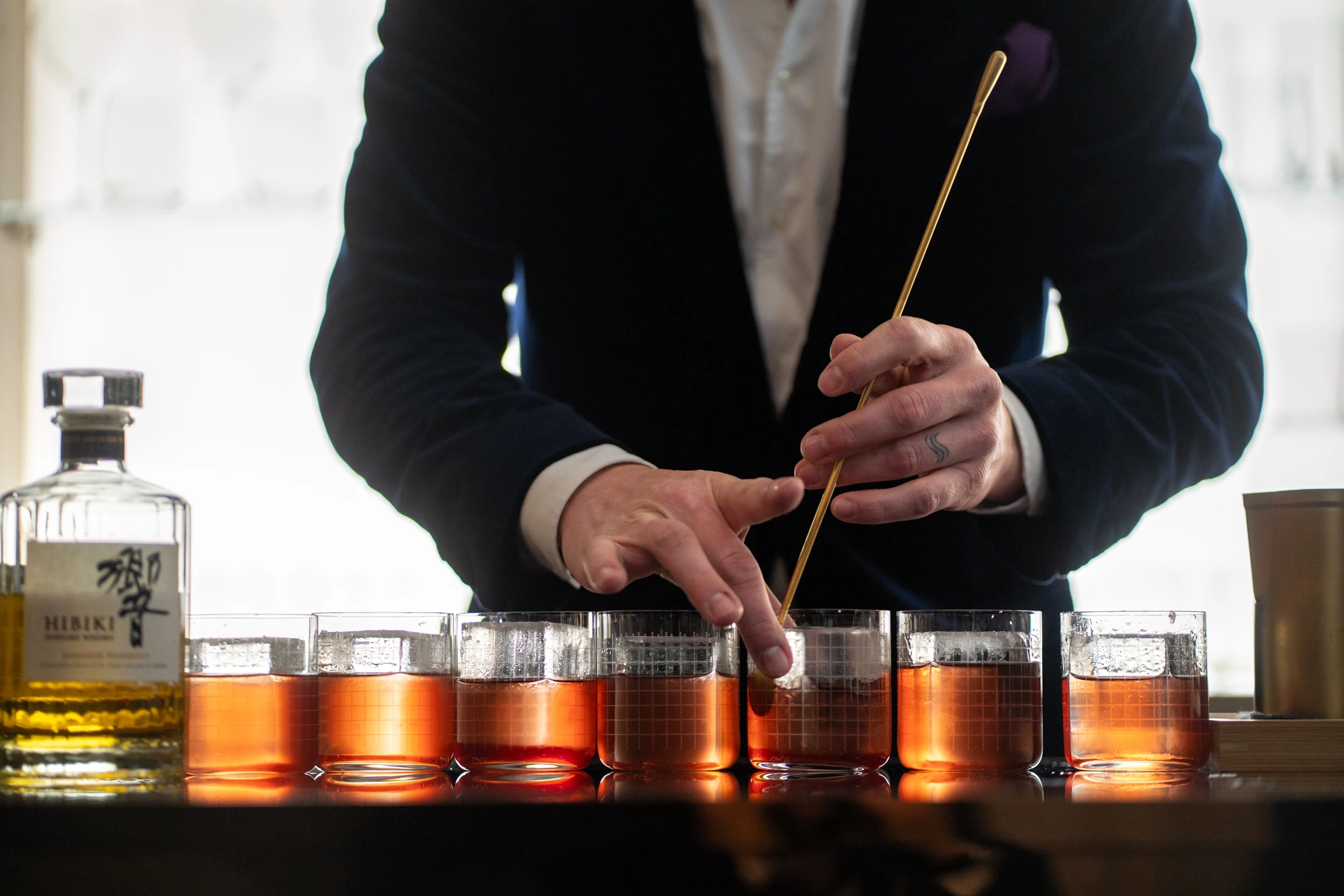 Homme préparant les verres du whisky Hibiki