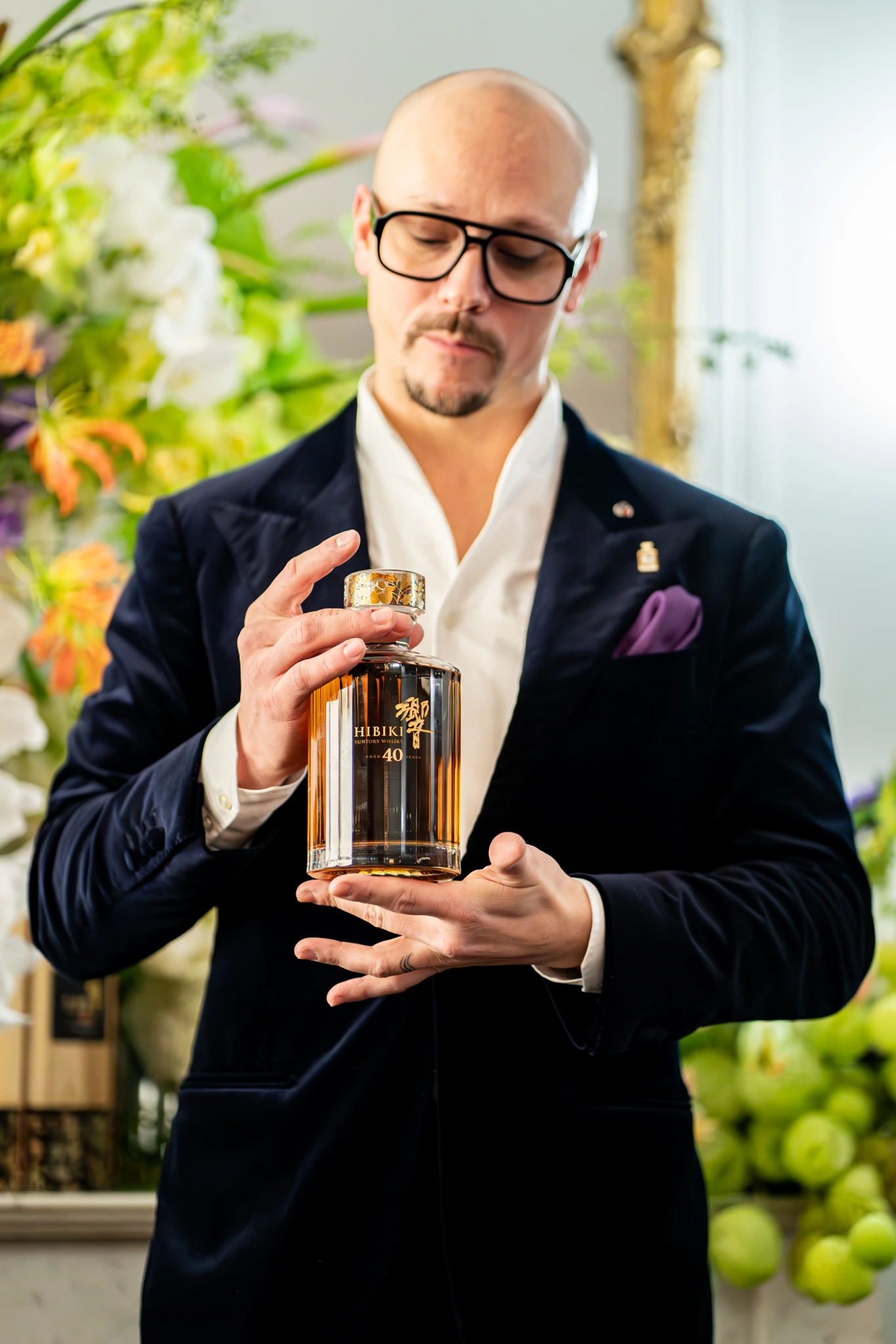 Homme en train de parler avec la bouteille du whisky Hibiki en main lors d'un événement