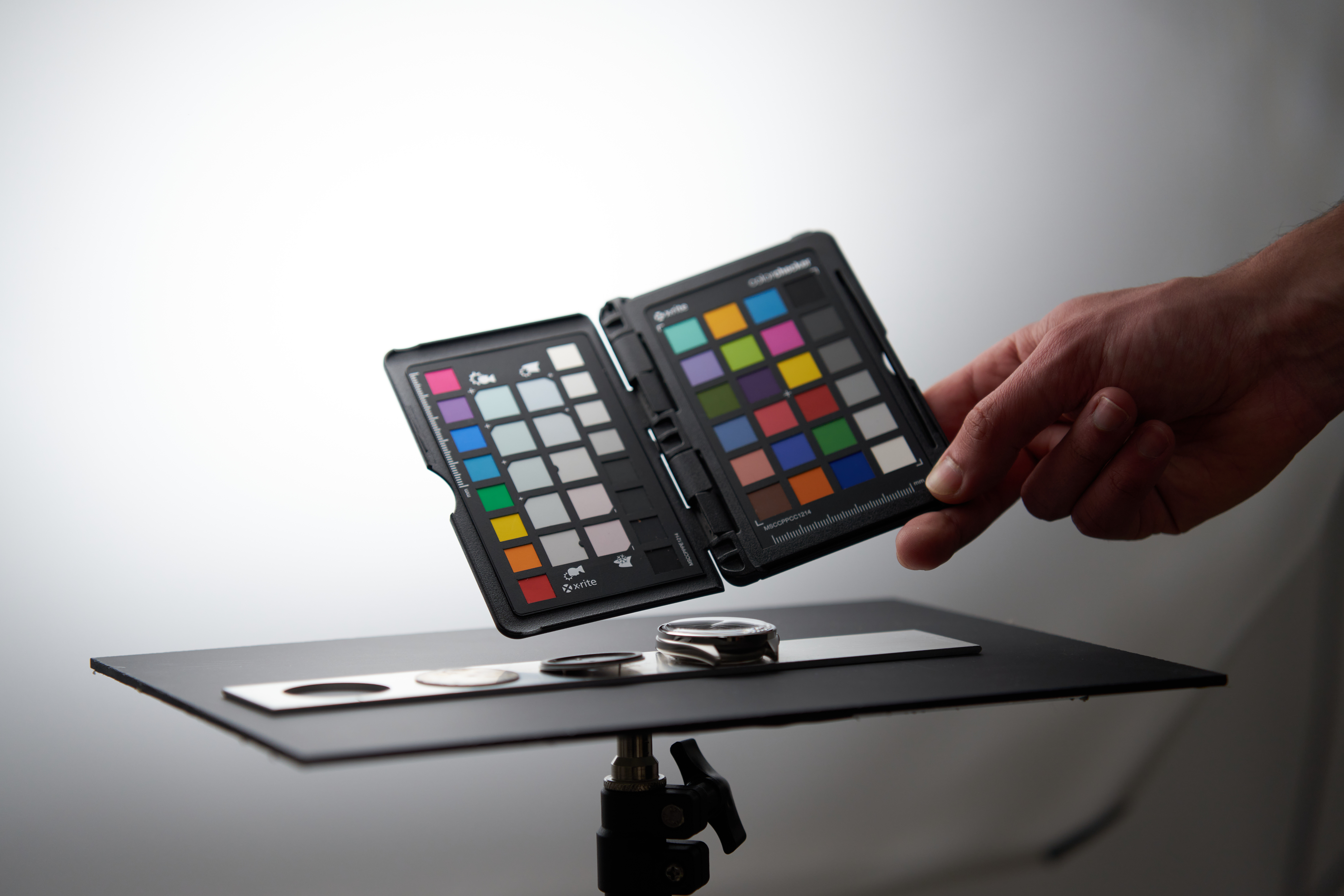 Backstage Jalaper V0 – Backstage 106 Main tenant une charte colorimétrique au-dessus d’une montre posée sur une table de studio