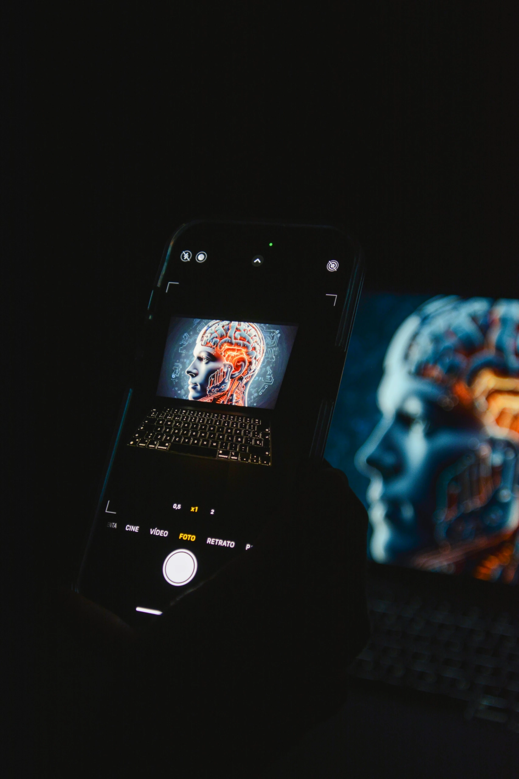 Gros plan d'un smartphone photographiant un écran d'ordinateur portable montrant une tête numérique avec des circuits, démontrant la retouche de photos basée sur l'IA.