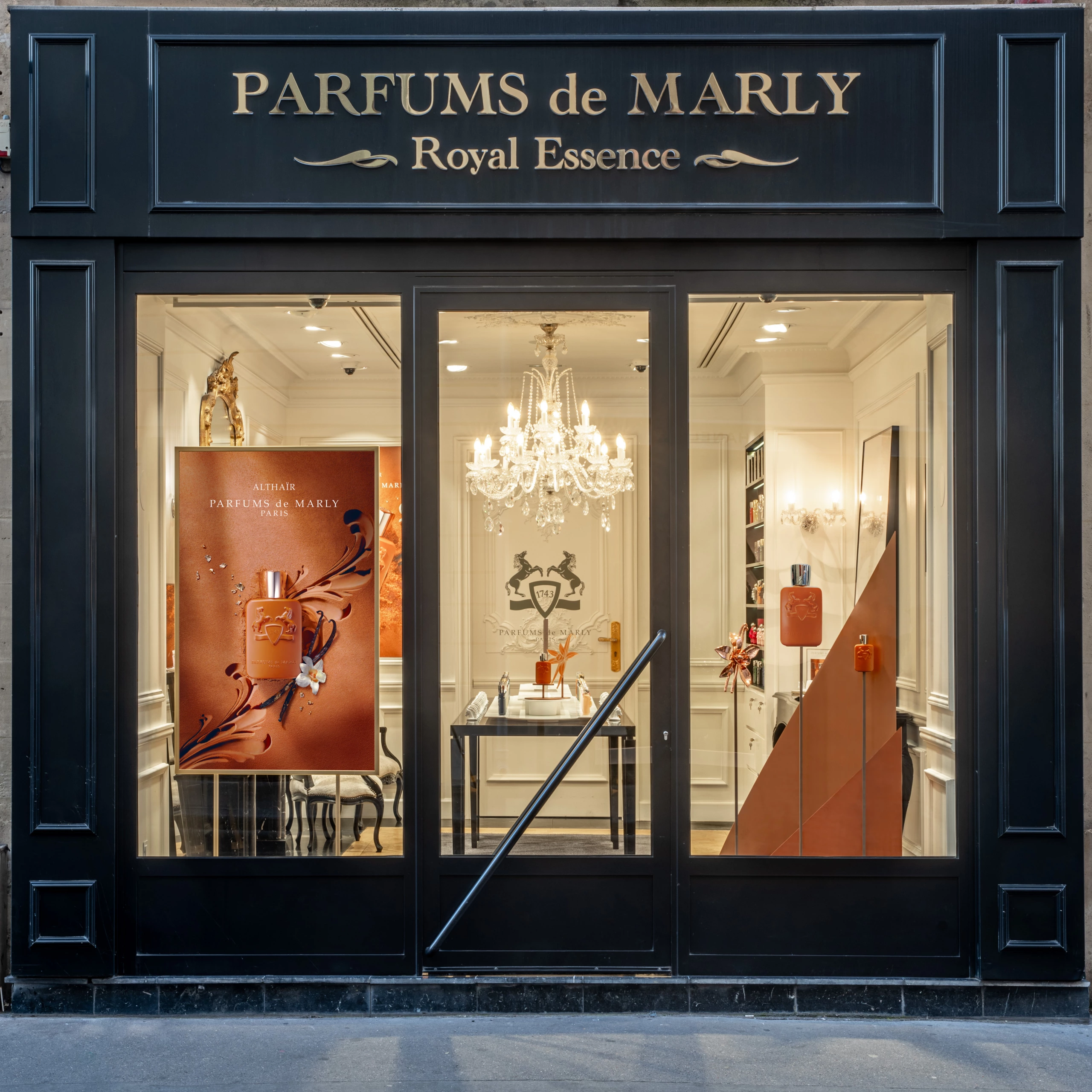Photo de la boutique Parfums de Marly à Paris, enseigne noire et or, portes vitrées, intérieur éclairé à la lumière naturelle.