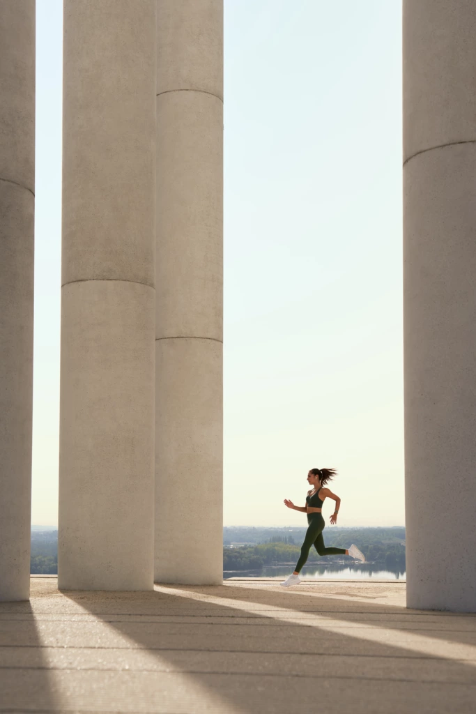 Athlète courant en extérieur entre des colonnes architecturales pour illustrer la montre connectée Garmin EPIX.