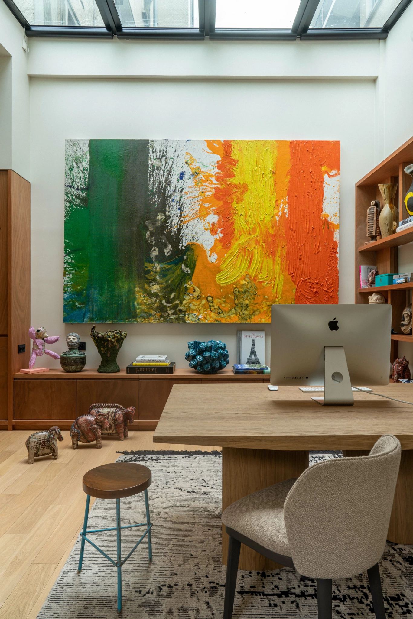 Espace de travail Paris 6ème 5 Bureau à domicile contemporain composé d'un bureau en bois, d'un iMac, d'œuvres d'art abstraites, d'étagères et d'un puits de lumière offrant un éclairage naturel pour la photographie.