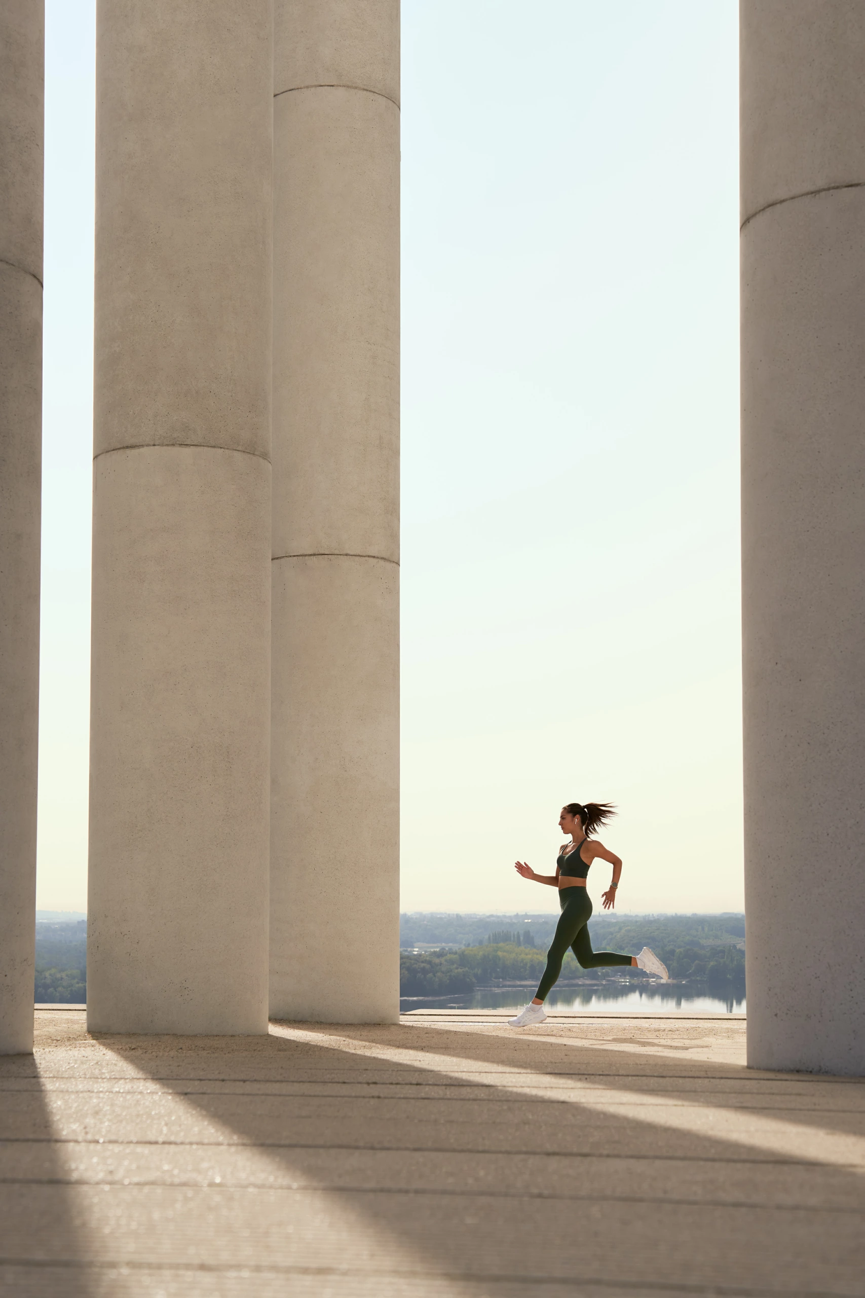Athlète courant en extérieur entre des colonnes architecturales pour illustrer la montre connectée Garmin EPIX.
