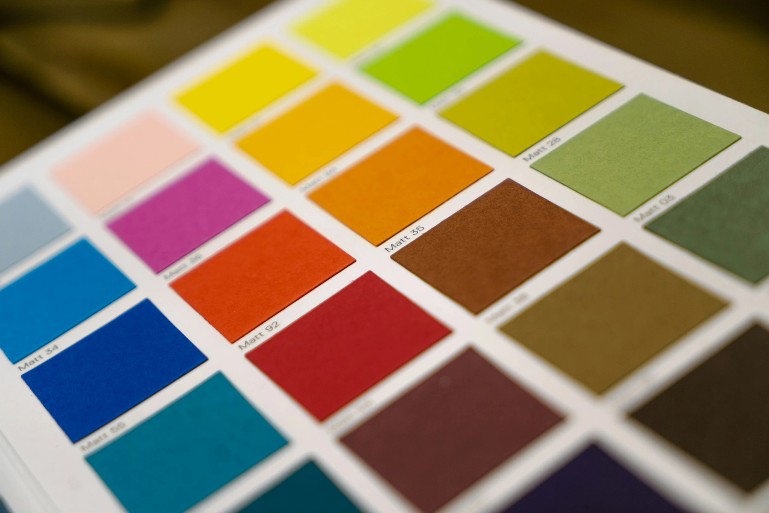 Gros plan d'une feuille d'échantillons de palette de couleurs imprimée avec des échantillons rectangulaires en rangées, chacun étiqueté, utilisés comme référence pour l'éclairage en studio.