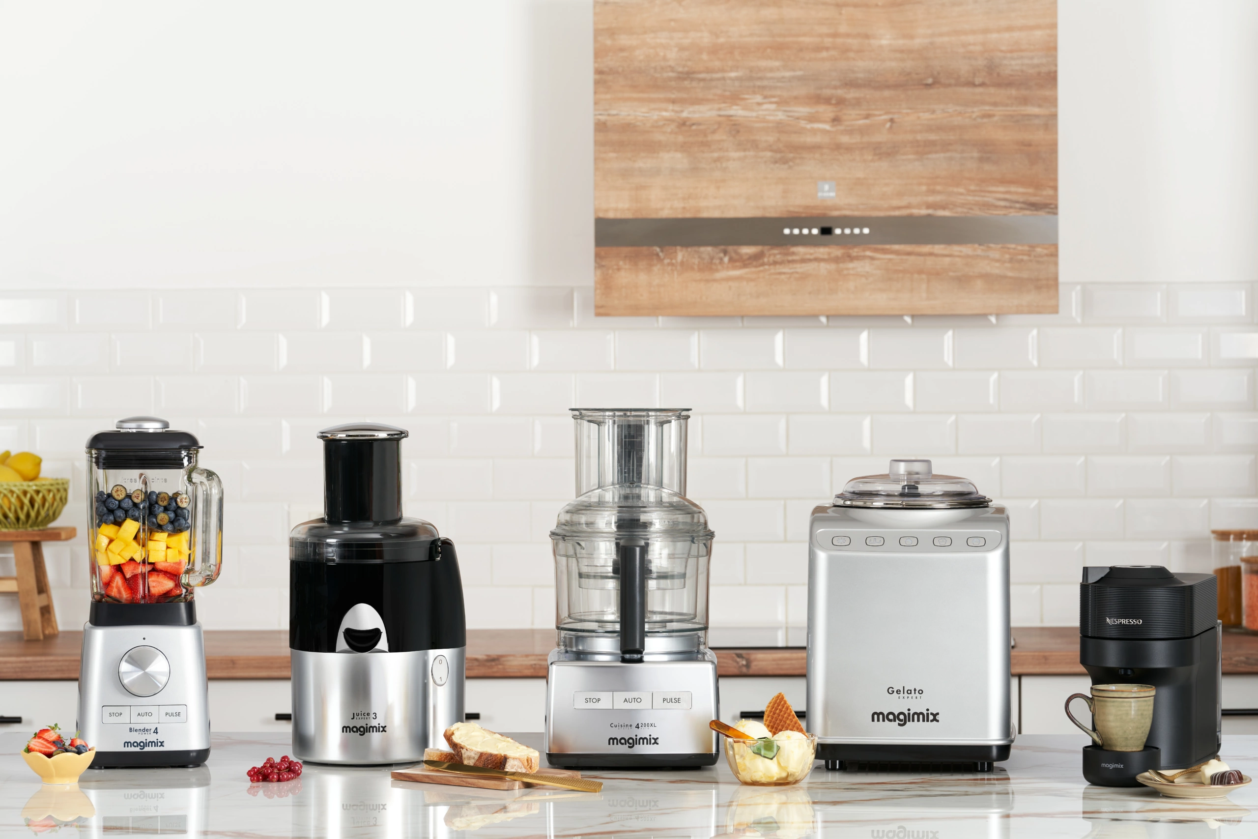 MAGIMIX – 10 Cinq appareils de cuisine Magimix disposés sur un plan de travail en marbre, dans un studio de photographie culinaire professionnel.