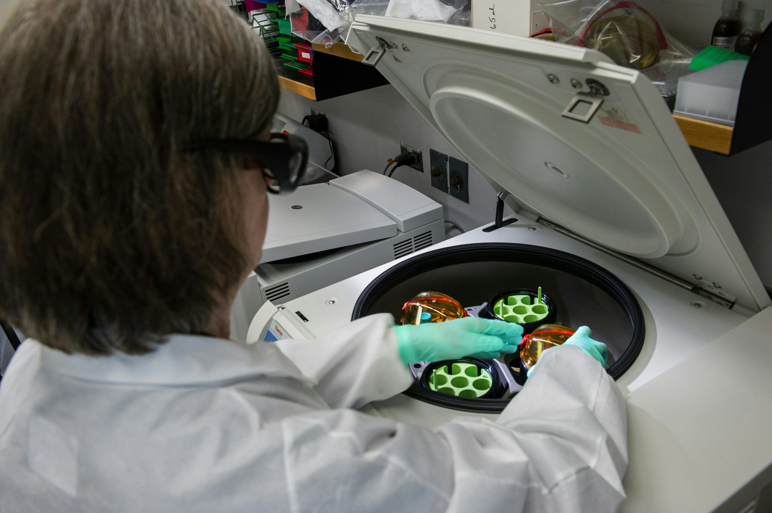 Photographie d’une technicienne de laboratoire manipulant une centrifugeuse
