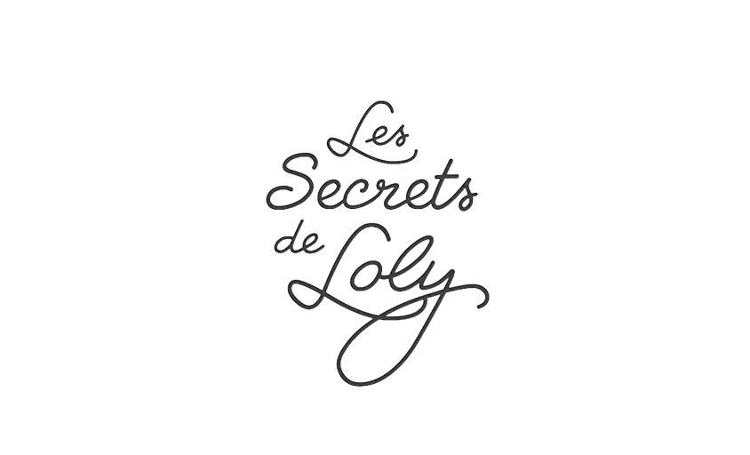 Le logo indique Les Secrets de Loly en police cursive noire, sur un fond blanc uni, adapté à une utilisation photographique de la marque.