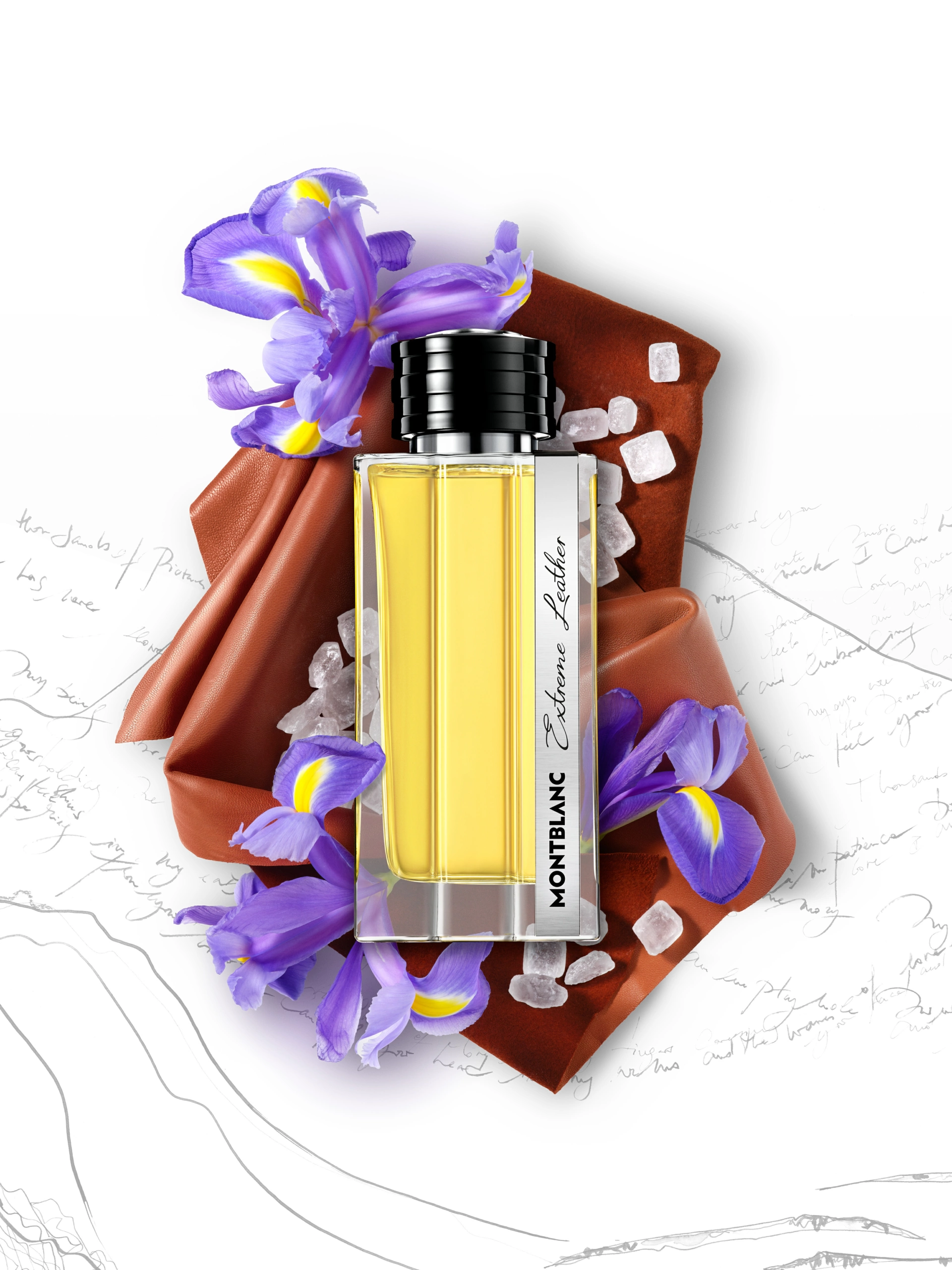 SOLO_MONTBLANC_EXTREME_LEATHER_DEF Un flacon de parfum Montblanc Explorer Platinum est posé sur une surface en cuir marron, entouré d’iris violets et de glaçons, avec en arrière-plan des notes manuscrites et de simples croquis. Cette composition photographique met en valeur les textures et la mise en scène du produit à des fins commerciales.
